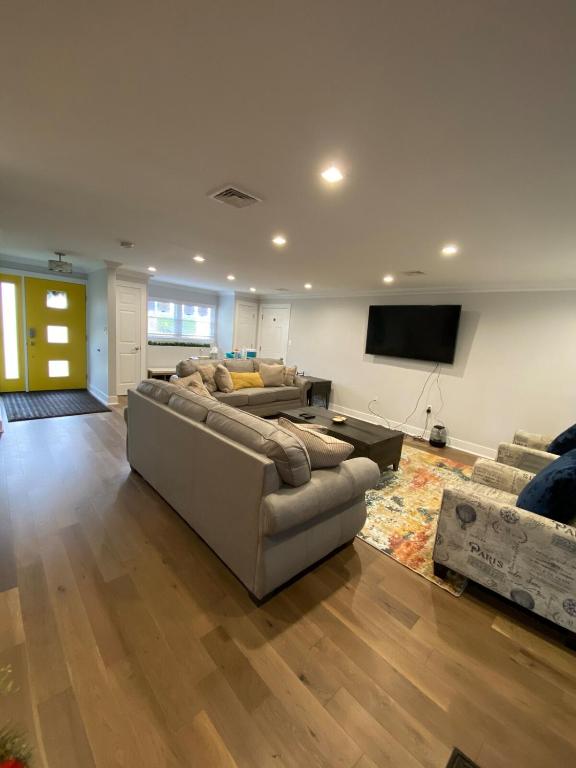 a living room with two couches and a flat screen tv at Matt Cozy Quarters in Orangeburg