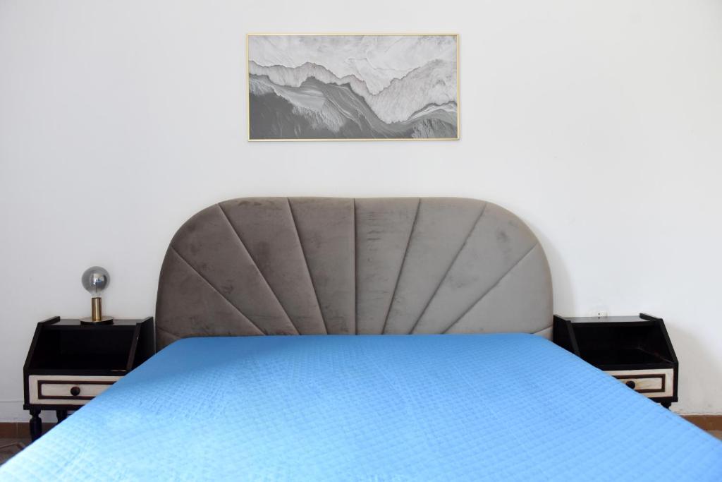 a bed in a room with a blue bedspread at Harit16 in Lecce