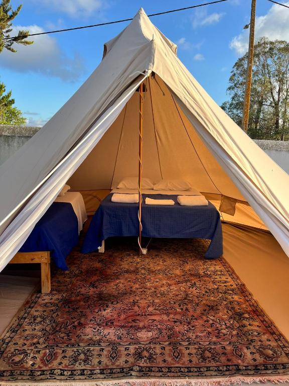 a tent with two beds in it on a rug at LOUSAL TENTS Grandola in Lousal