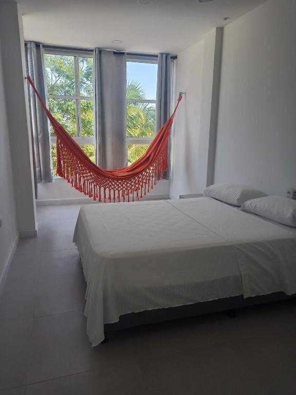 a bedroom with a hammock in front of a window at Hotel La Cima in Arboletes