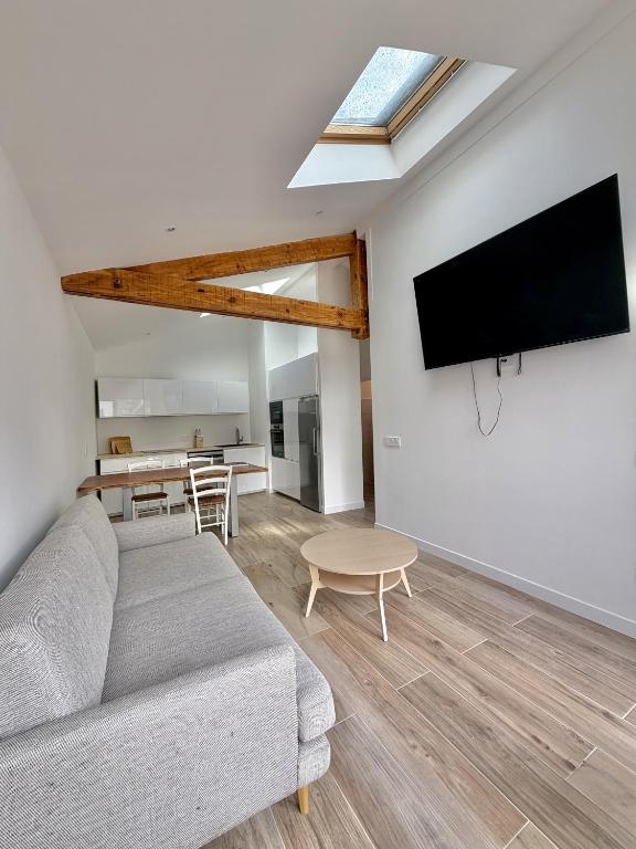 a living room with a couch and a flat screen tv at Bed & Breakfast L'Etape Basque in Bidart