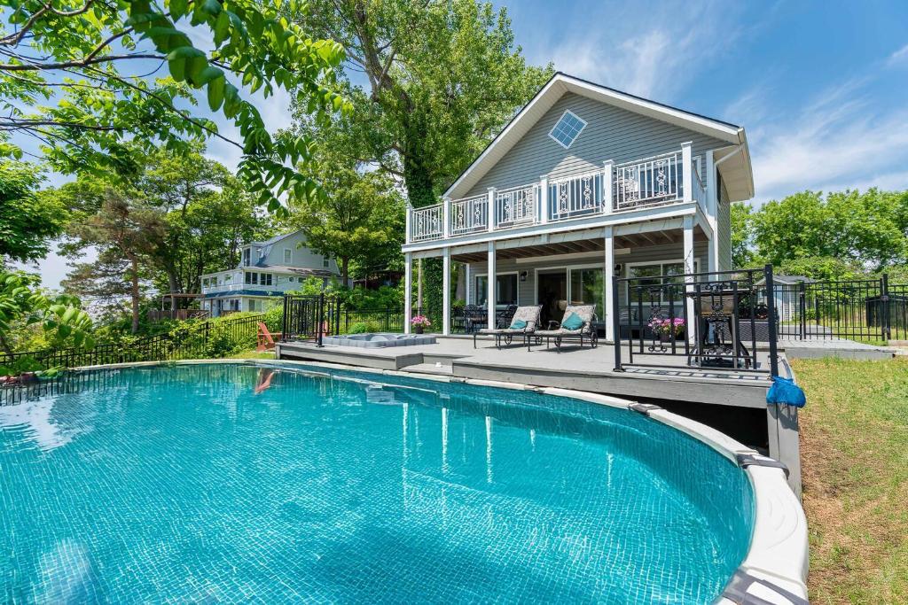 a large swimming pool in front of a house at Waterfront Cottage w Pool Beach Access in Fort Erie