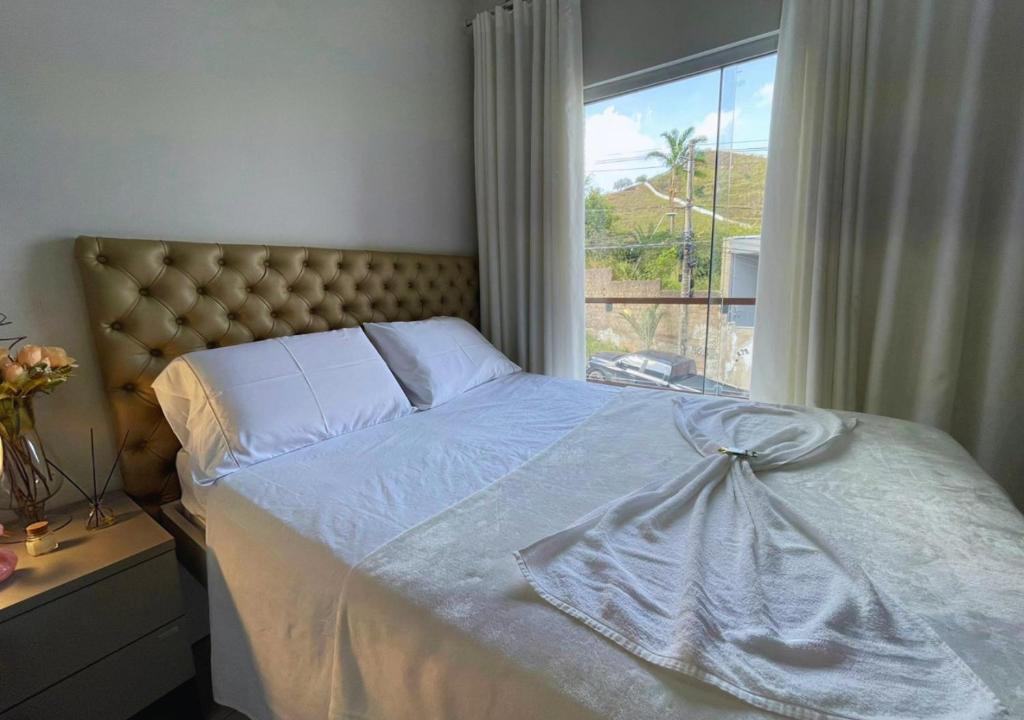 a bed in a bedroom with a large window at Dali Apart hotel in Ipatinga
