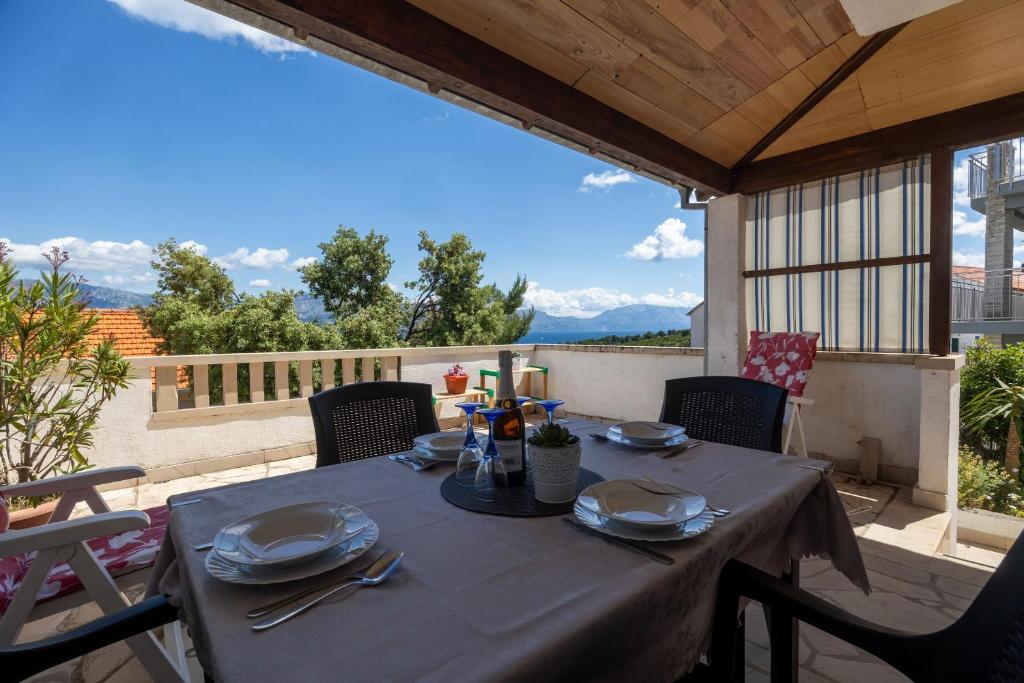 a table with plates and utensils on a patio at Apartments Soni in Postira