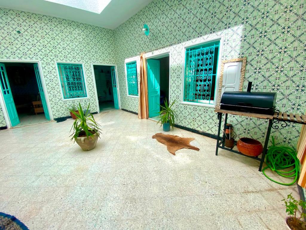 a living room with green walls and a television at Dar El Mdina in Mahdia