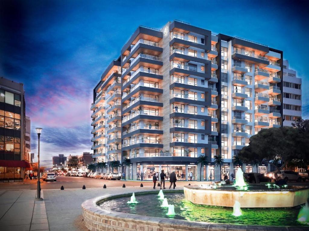 a large apartment building with a fountain in front of it at House Vista Azul in Puerto Madryn