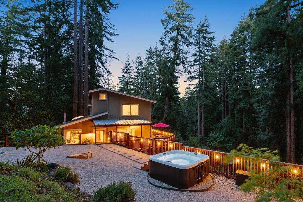 a house with a bath tub in the middle of a yard at Redwood Oasis - Luxe Santa Cruz Cabin w/ Hot Tub in Ben Lomond