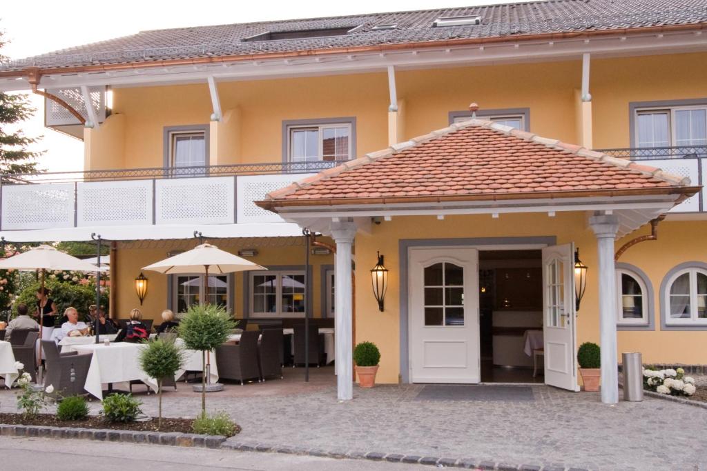 ein gelbes Haus mit einer weißen Tür und einer Terrasse in der Unterkunft HIRSCH1783 Hotel LANDHAUS in Langenargen