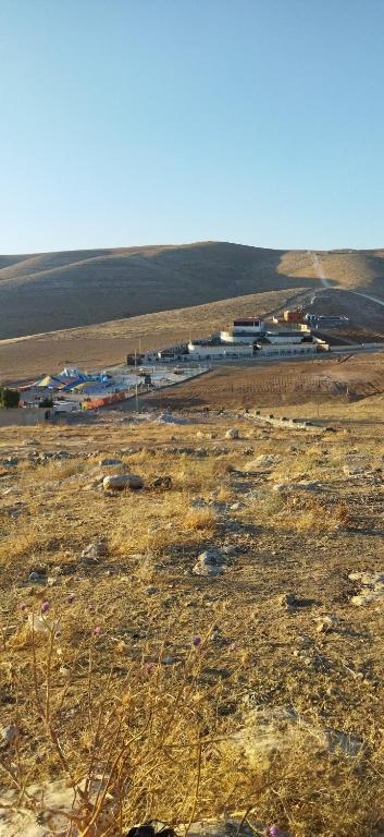 a field with a group of buildings in a field at Welcome back in Al Hāshimīyah