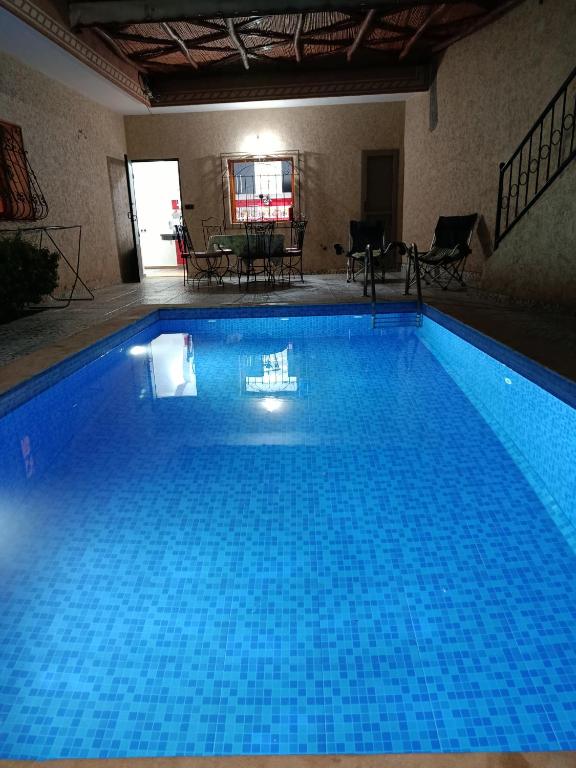 a large blue swimming pool in a building at villa ourika complette in Sbiti