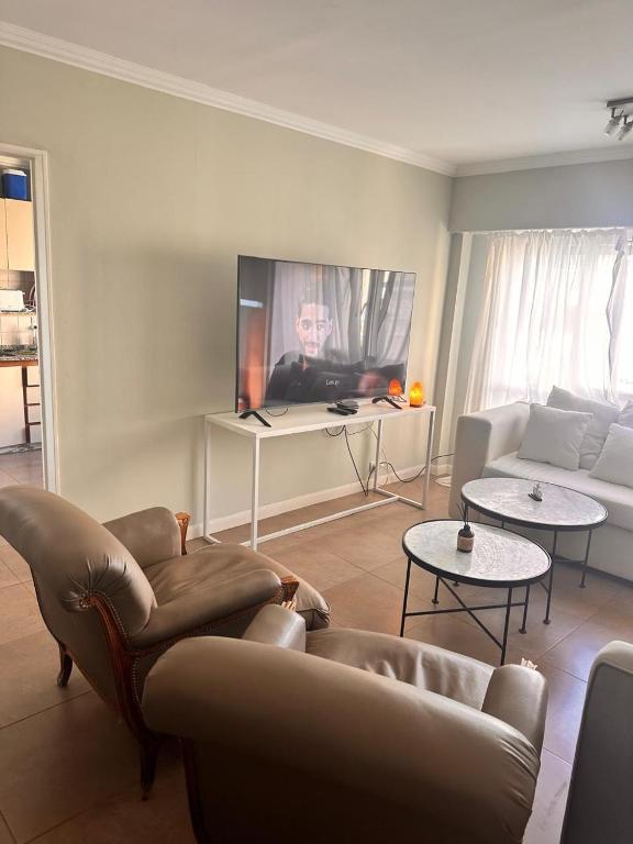 a living room with a couch and chairs and a tv at Apart Jose in Comodoro Rivadavia