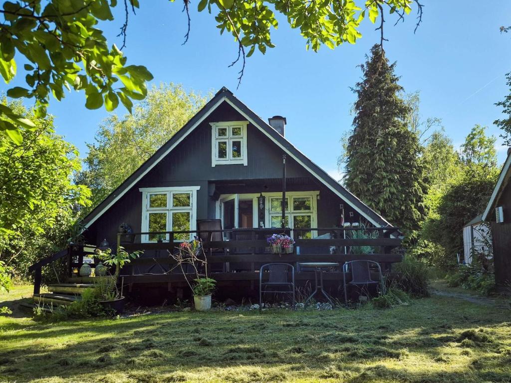 a black house with a tree at 4 person holiday home in Odder in Odder