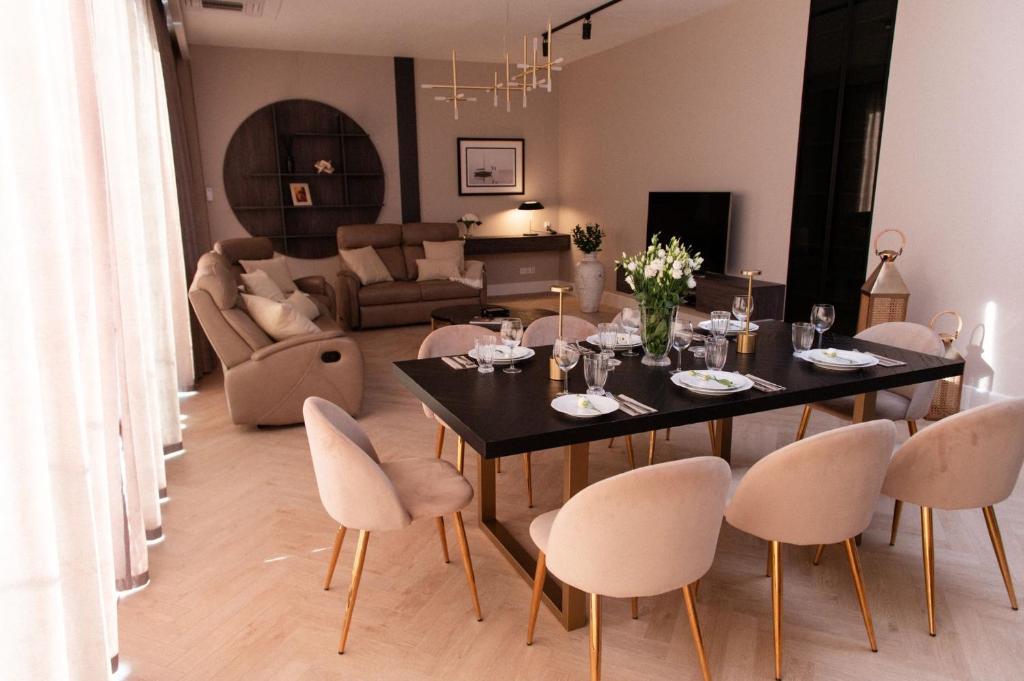 a dining room and living room with a table and chairs at Amber Sun Towers 11th Floor in Świnoujście