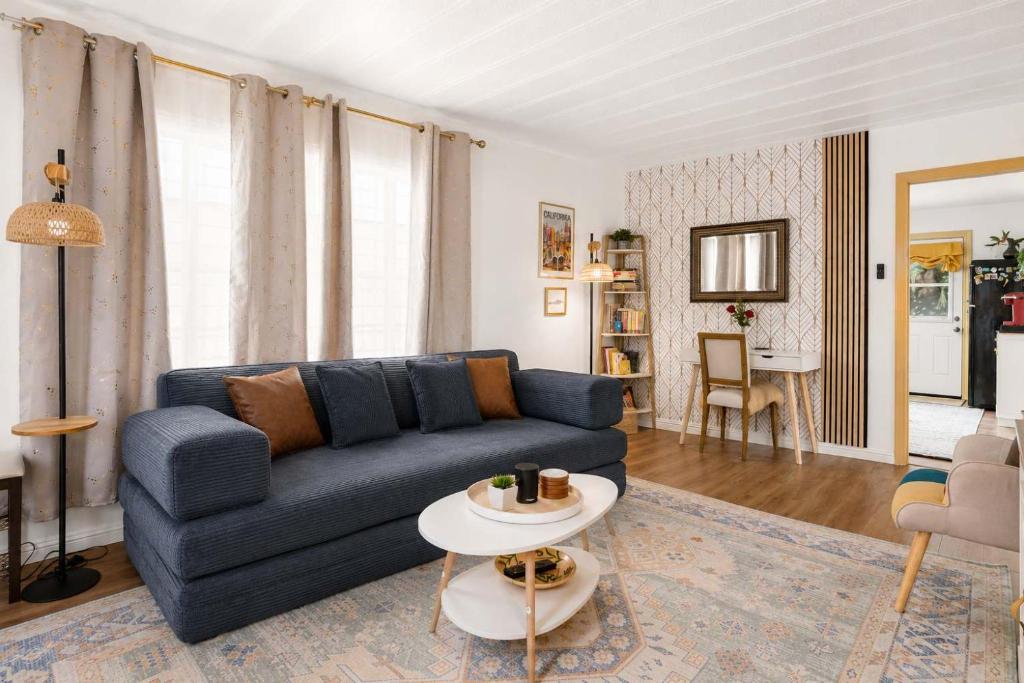 a living room with a blue couch and a table at Ocean glimpse from the patio in Pacifica