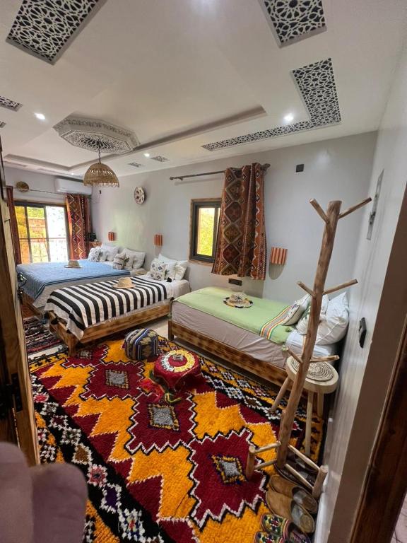 a room with two beds and a rug at Atlas Horizon Lodge in Imlil