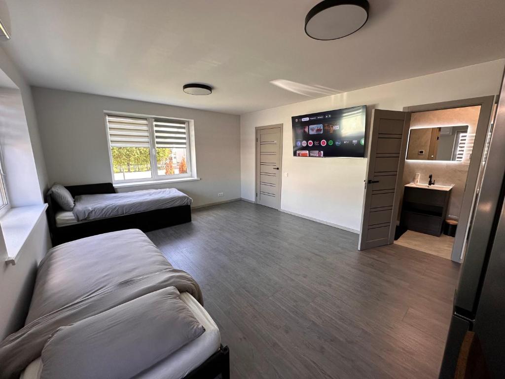 a room with a bed and a couch and a tv at Cozy Spark Studio Apartment in Kelmė