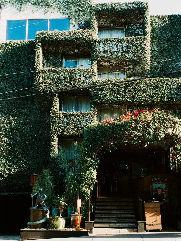 a building covered in ivy with stairs and flowers at Petit Ermitage in Los Angeles
