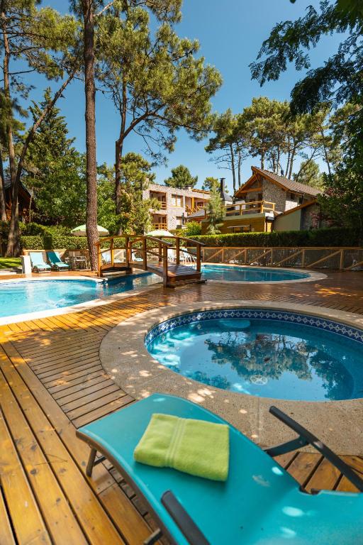 a swimming pool with a wooden deck and a hot tub at Cabañas Mapuche in Mar de las Pampas