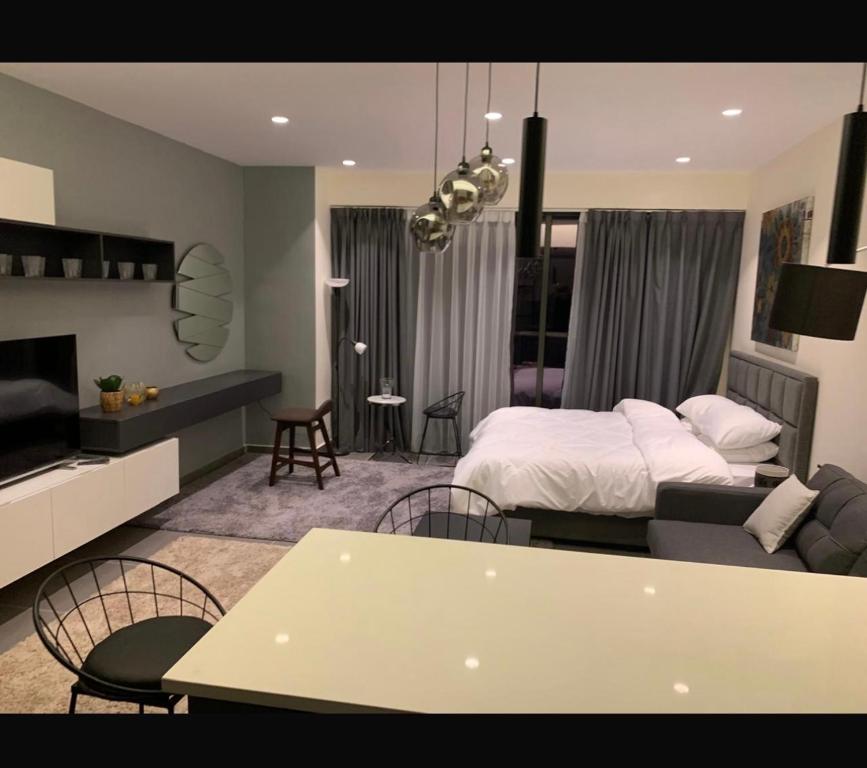 a bedroom with a bed and a living room at Amman studio Damac Tower in Amman