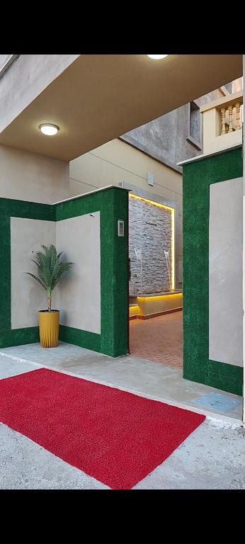 a green and white wall with a red rug and a plant at Nekor Bay Villa in Al Hoceïma