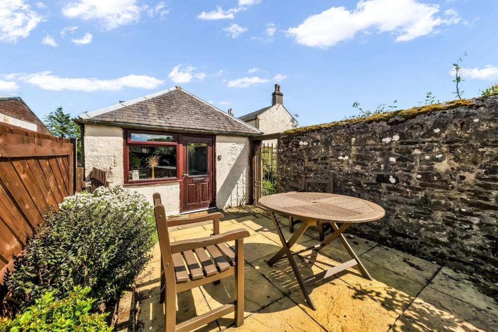 a patio with a table and a chair and a building at The Bothy in Dundee