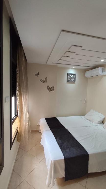 a bedroom with two beds and a window at Nekor Bay Appartement in Al Hoceïma