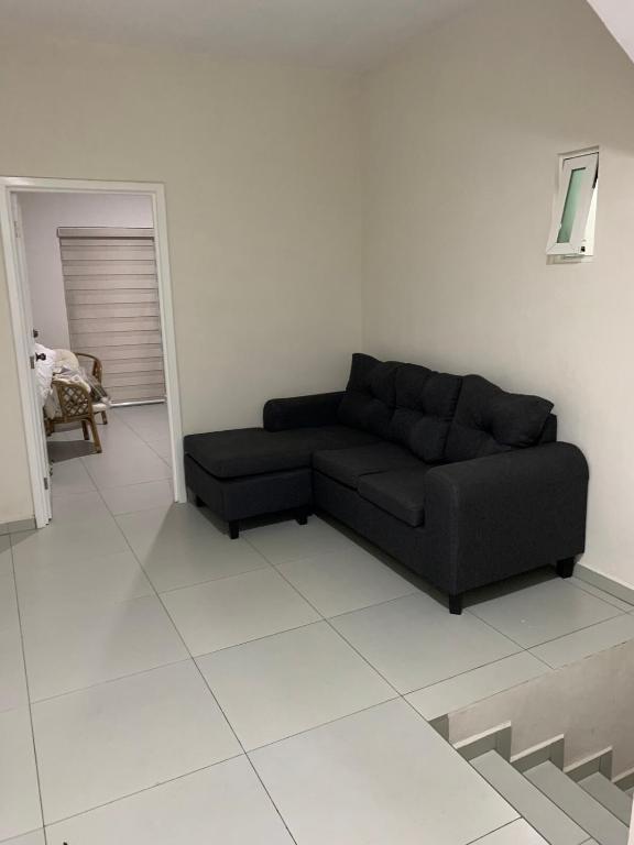 a living room with a black couch in a white room at Casa de la Playa in Playa Azul