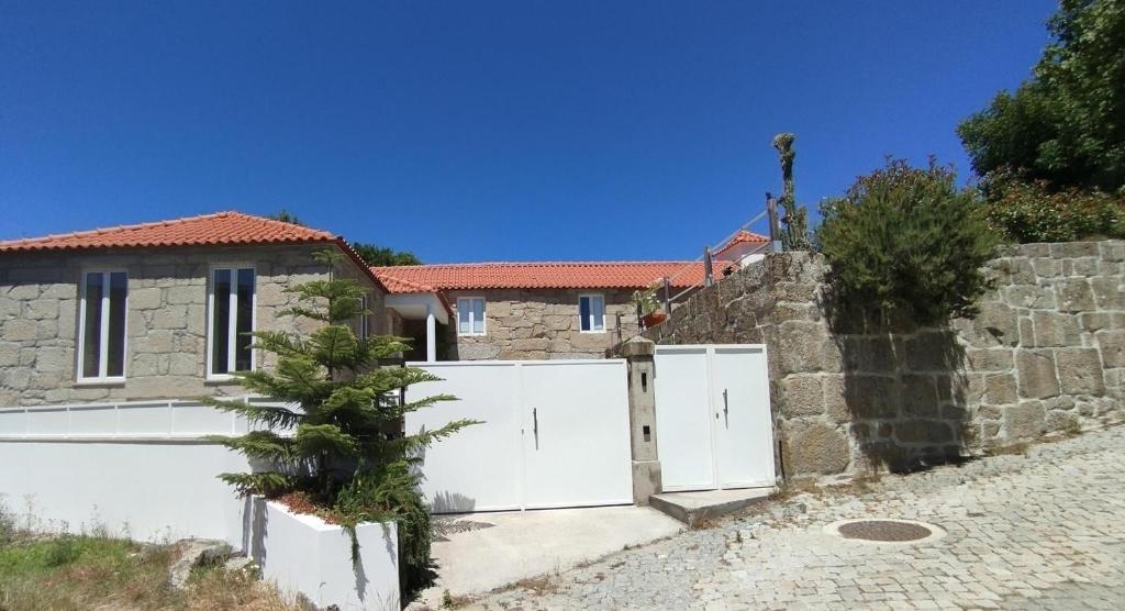 a house with a white gate and a stone wall at Casa da Aldeia in Santa Cruz do Douro