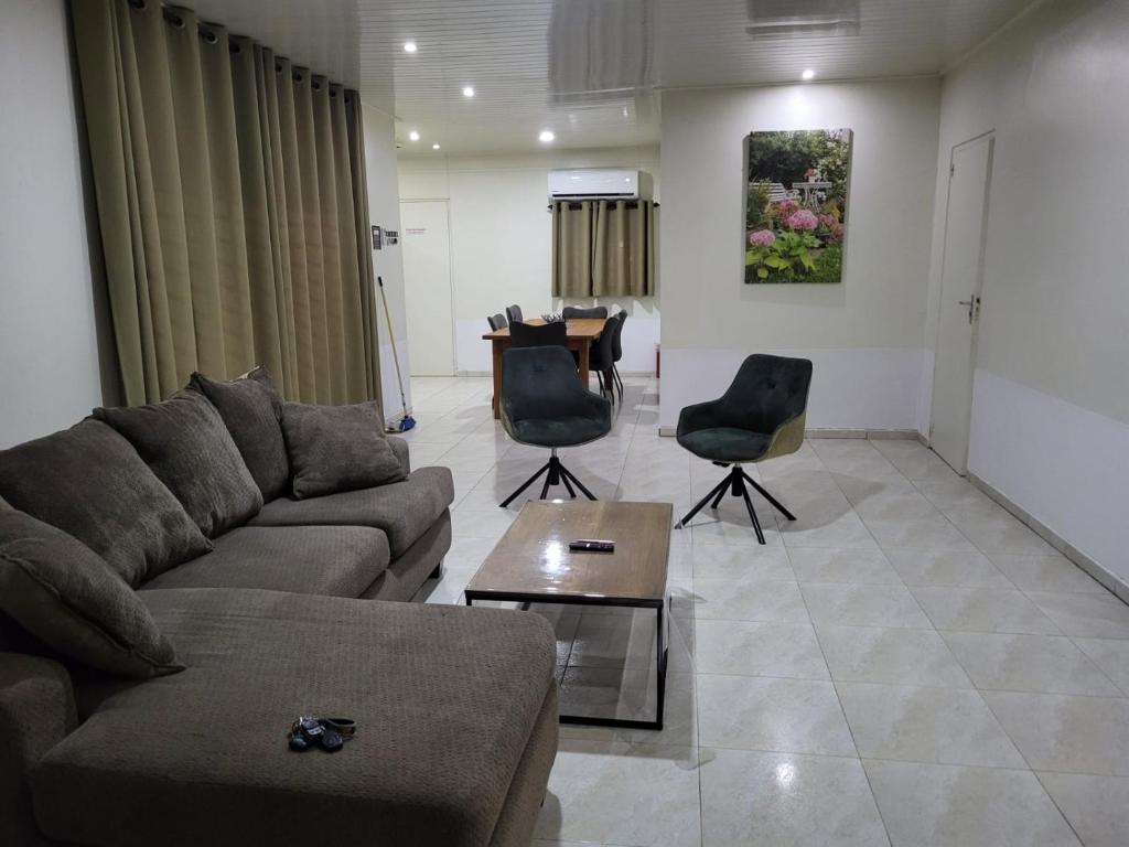 a living room with a couch and chairs and a table at Serenity Appartementen 2 in Paramaribo