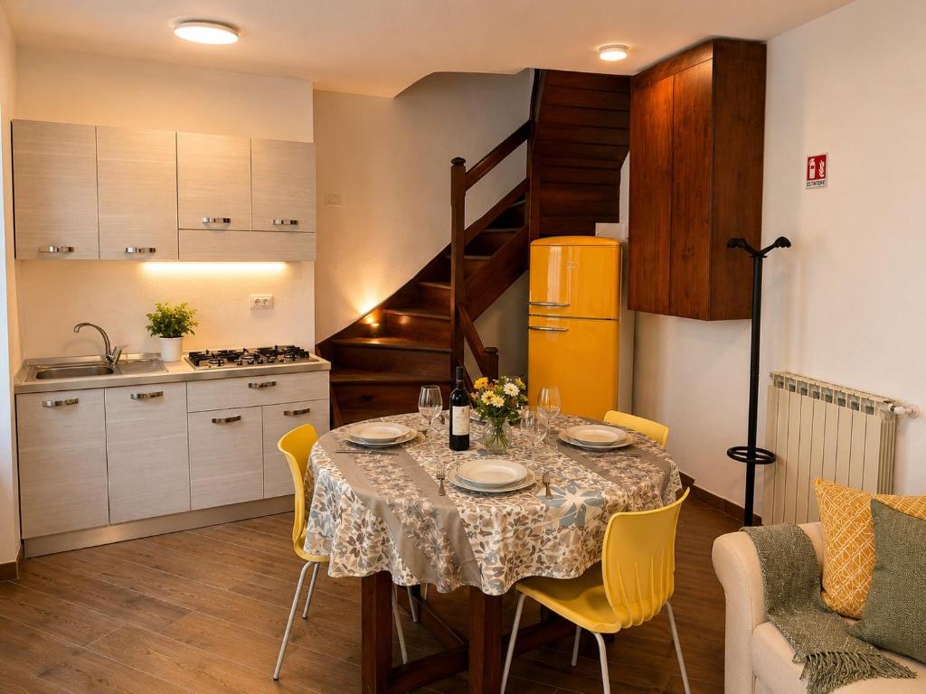 a kitchen and dining room with a table with yellow chairs at Ca' Santa Maria in Santa Maria Maggiore