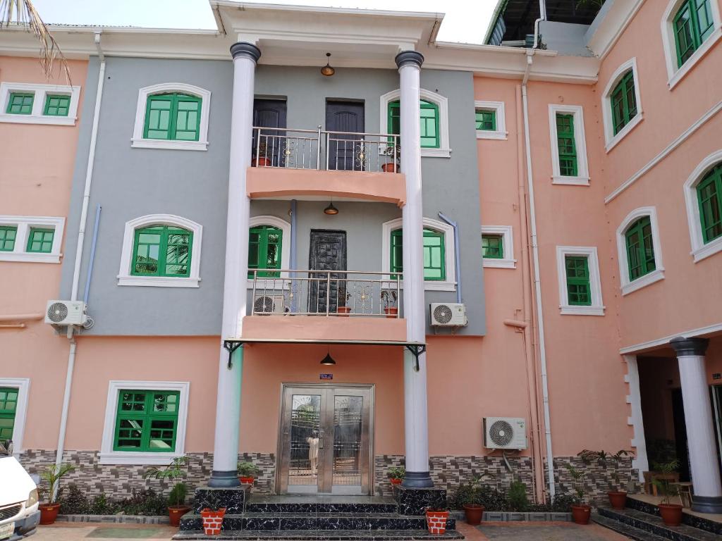 a large building with green doors and windows at MF Supreme Hotels and suites in Ikorodu