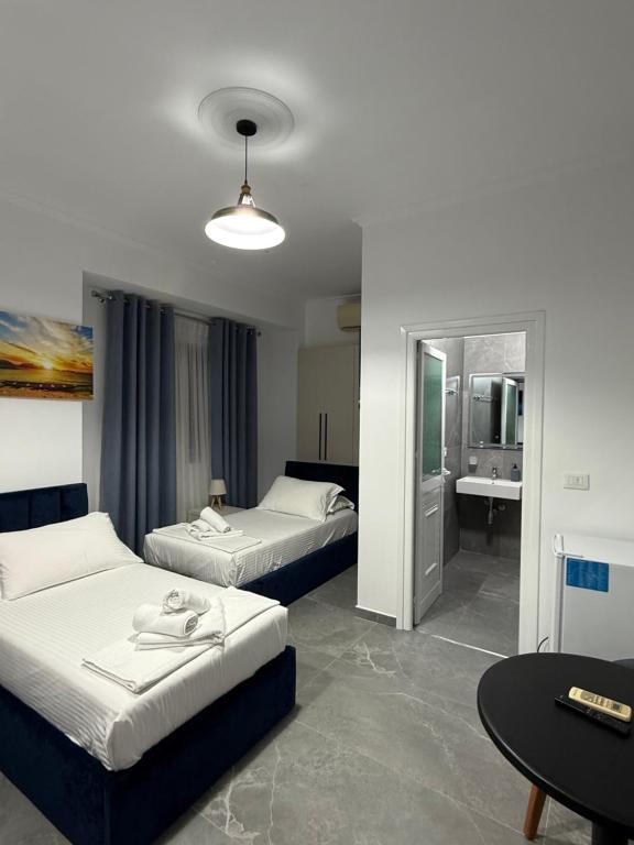 a hotel room with two beds and a bathroom at Nivro in Delvinë