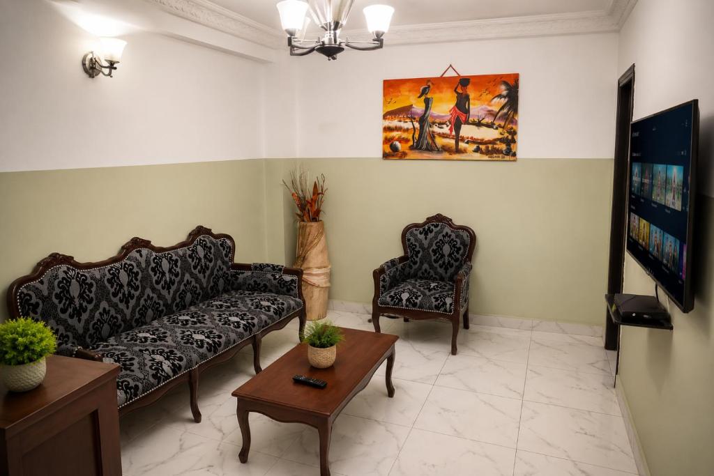 a living room with a couch and two chairs at TCHASSHOUSE Motel in Yaoundé