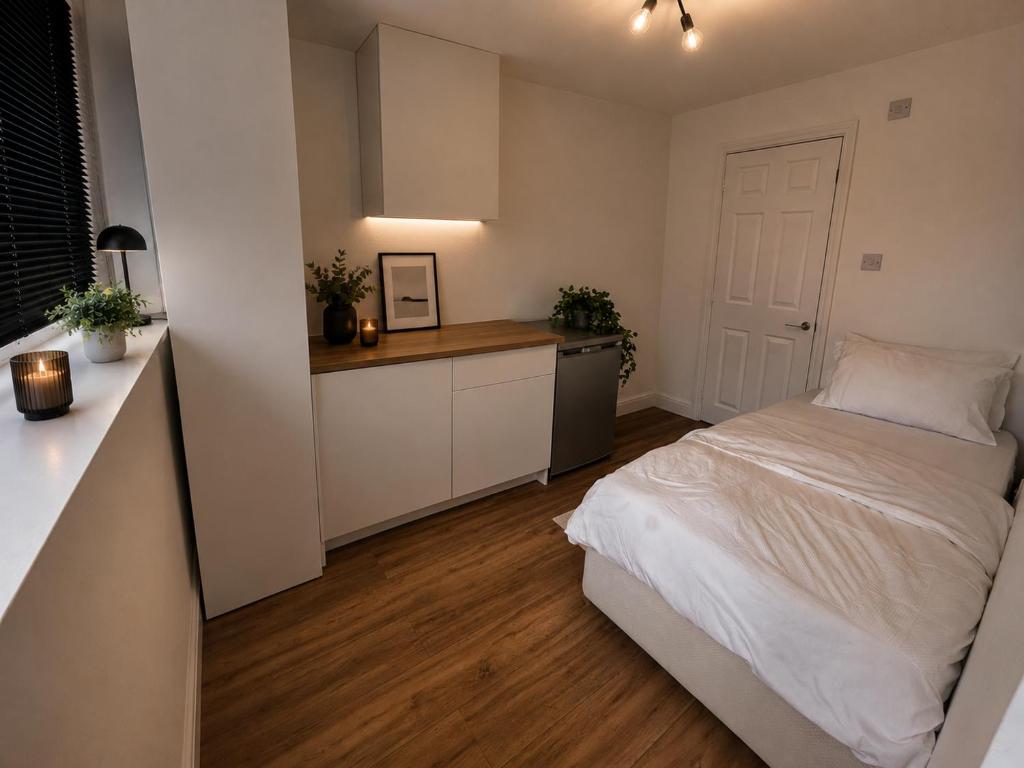 a small bedroom with a bed and a kitchen at Cosy in Windsor in Windsor
