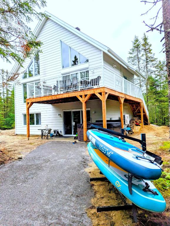a house with two kayaks parked in front of it at L'intemporel - Retro Chalet with Private Lake and Hot Tub in Valcartier Station