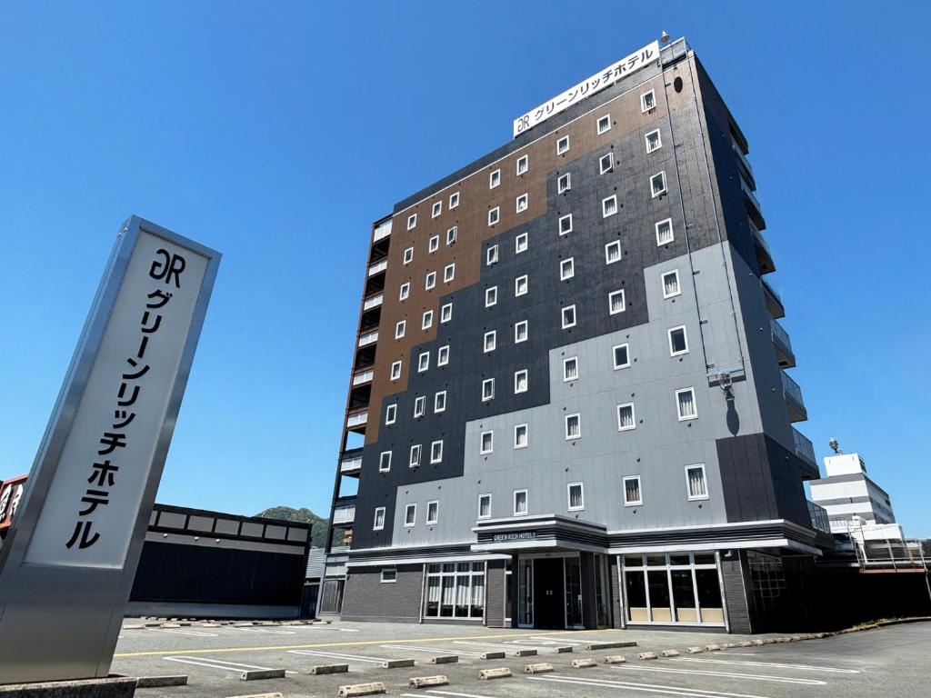 a hotel building with a sign in front of it at Green Rich Hotel Yamaguchi Yuda Onsen in Yamaguchi
