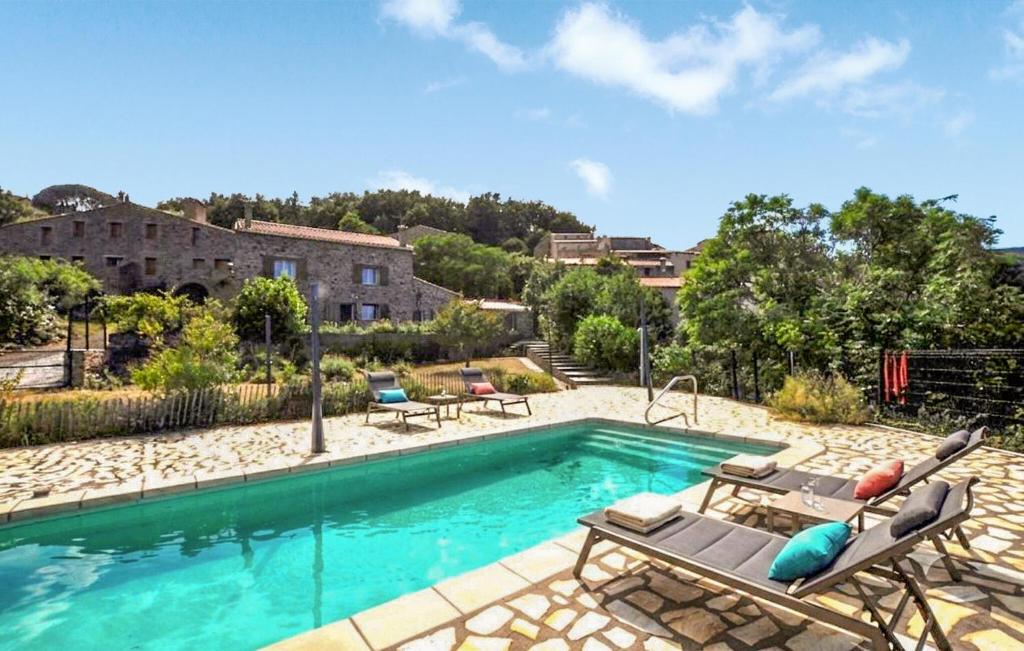a swimming pool with lounge chairs and a house at Charmante Villa Piscine in Taulis