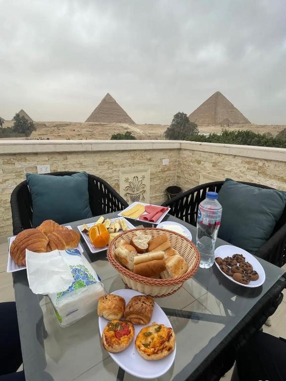 a table topped with plates of food on top of a pyramid at Casa pyramids hotel in Cairo