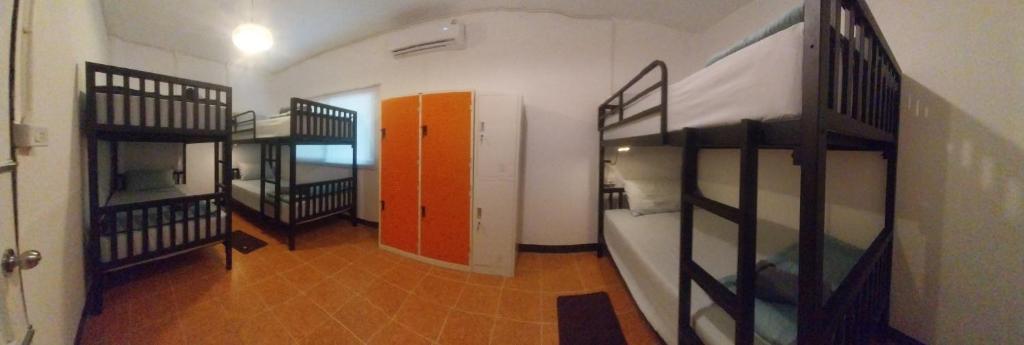 a room with two bunk beds and a hallway at Honey You HOSTEL in Ban Khlong Mat