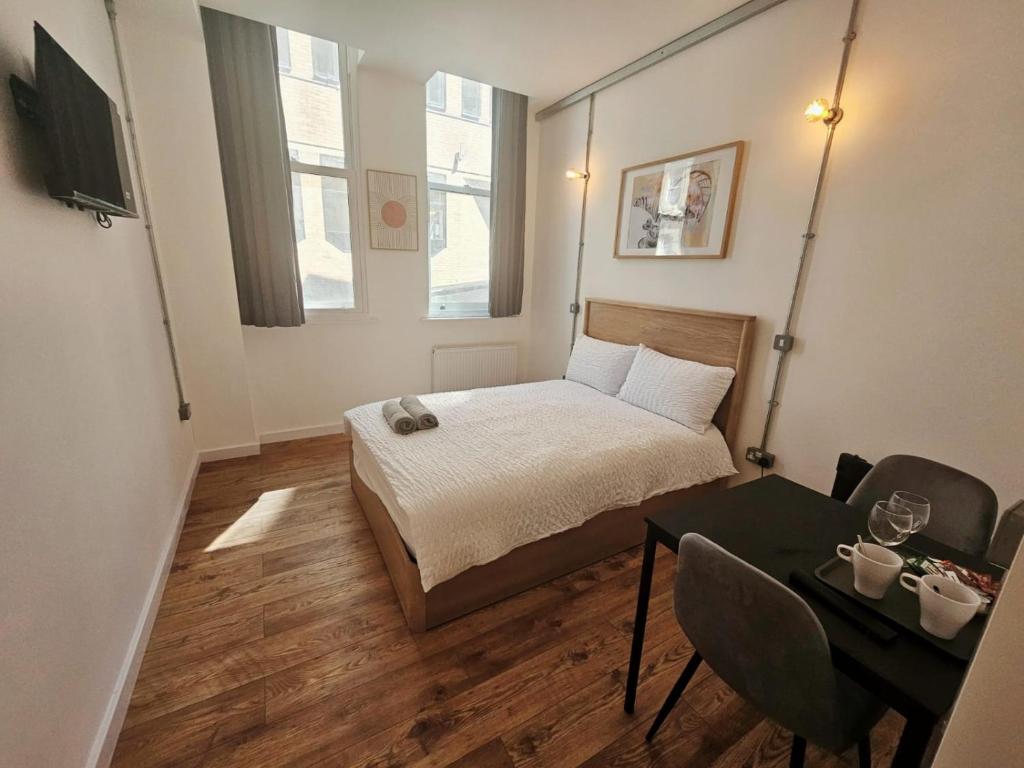 ein kleines Schlafzimmer mit einem Bett und einem Tisch in der Unterkunft The Nest Lite in Sheffield