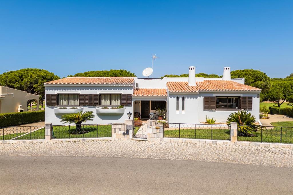 a white house with a fence in front of it at Vilamoura Escape with Private Pool in Vilamoura