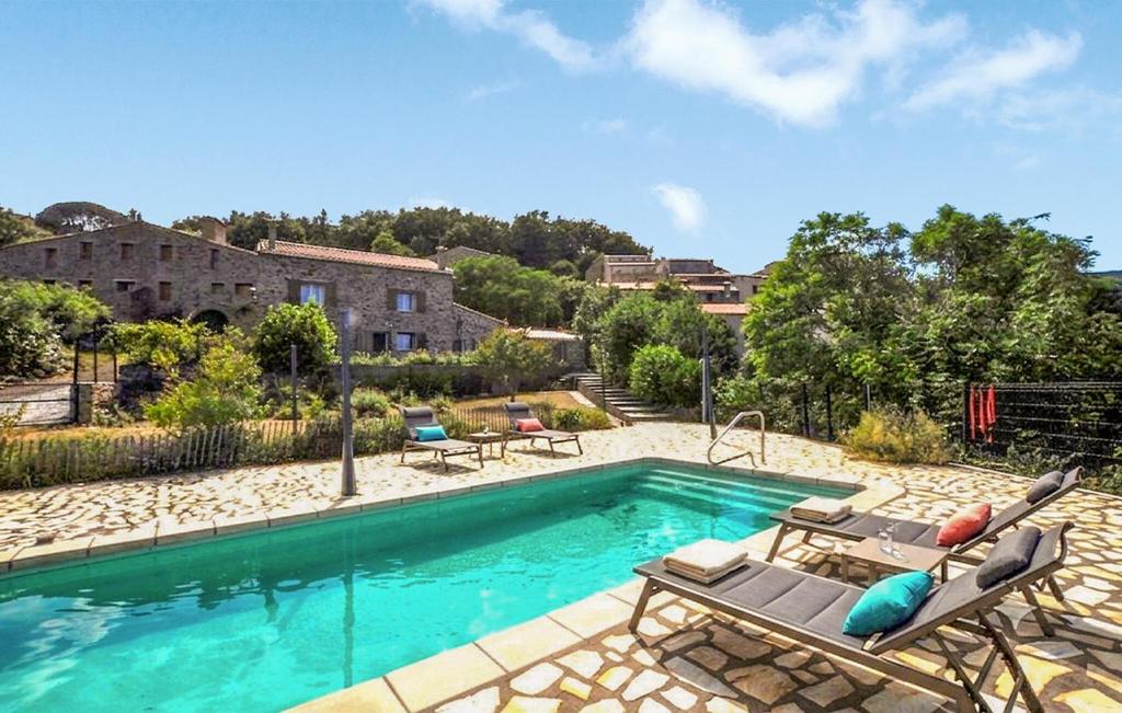 a swimming pool with lounge chairs and a house at Authentique Villa Piscine in Taulis