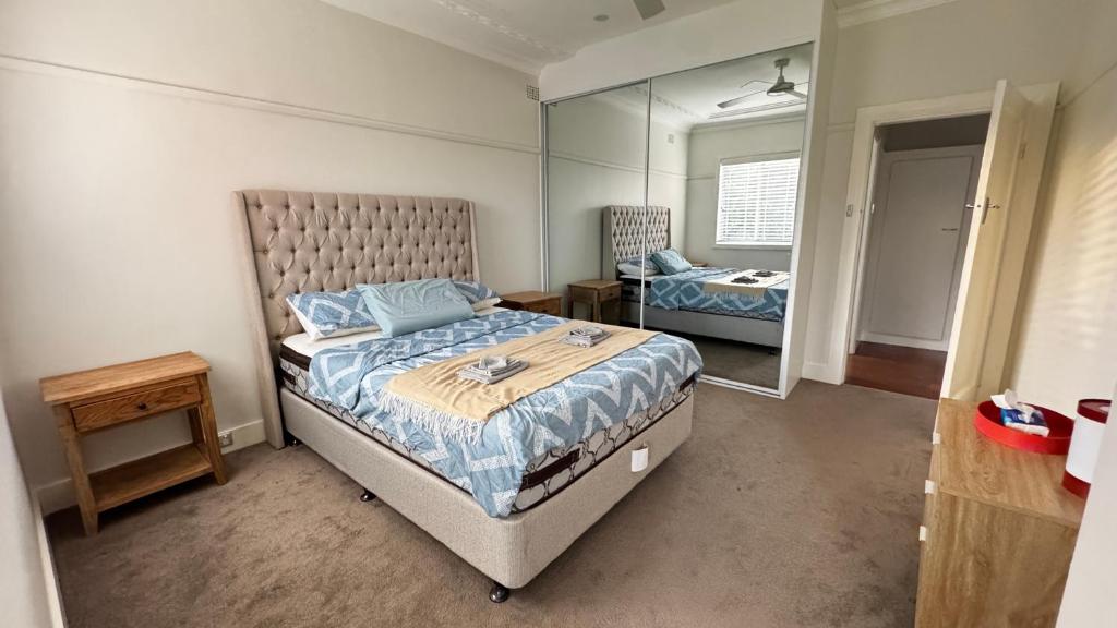 a bedroom with a bed and a large mirror at Main road apartment in Sydney