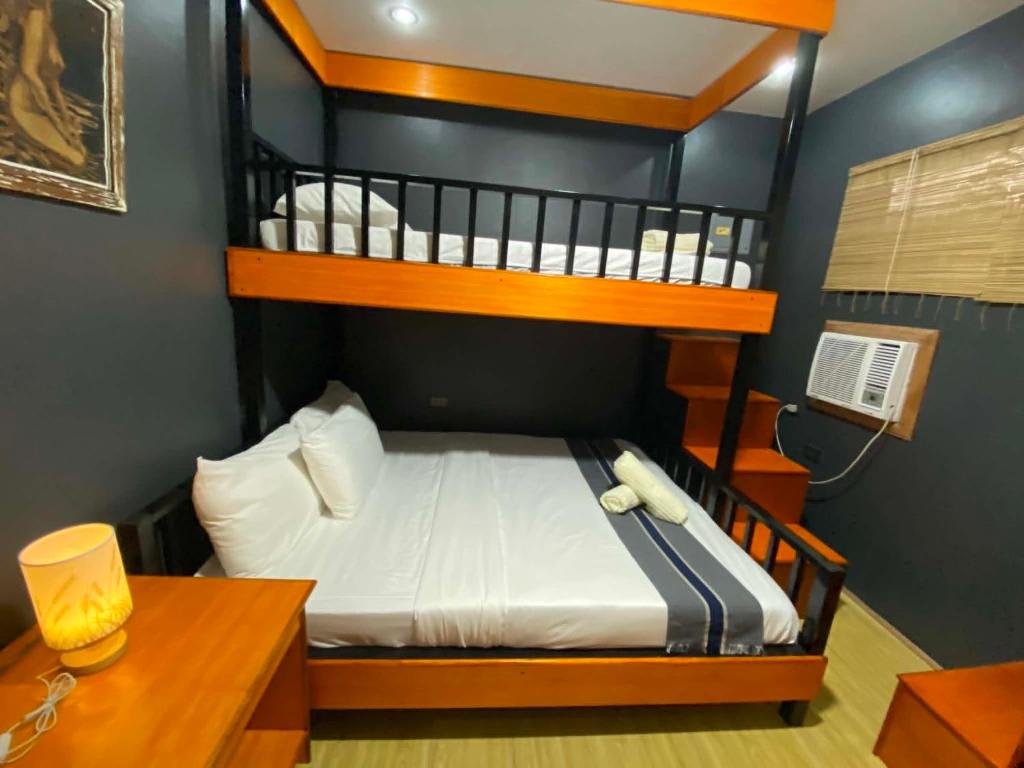 a bedroom with a bunk bed and a desk at Angkel's Place in Bangued