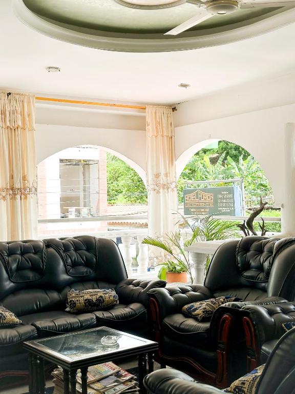 a living room with black leather couches and a table at Hotel Porton De Oriente in Puerto Triunfo