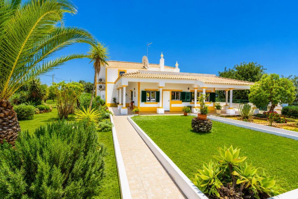 a house with a garden and palm trees at Villa Sol Nascente in Porches