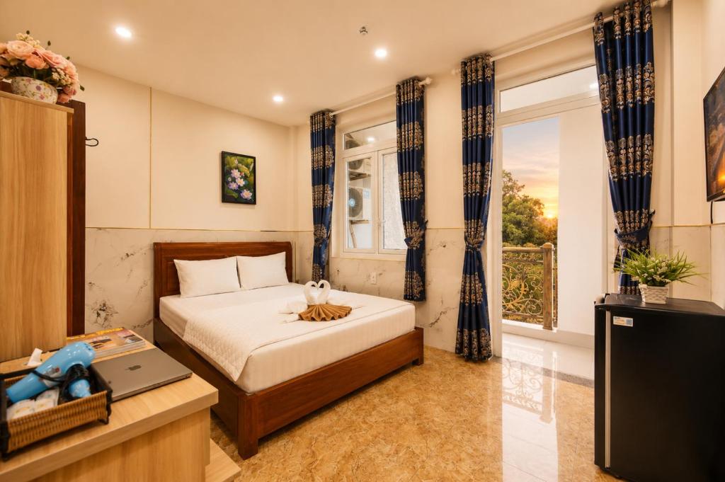 a bedroom with a bed and a television and a window at Yoyo Airport Saigon Hotel in Ho Chi Minh City