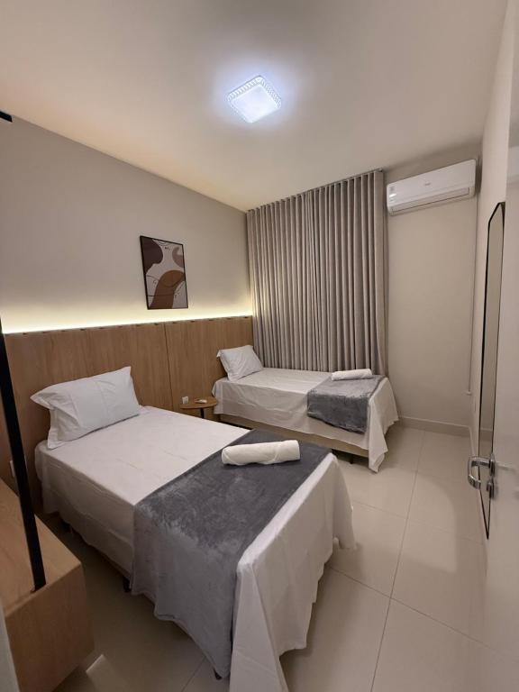 a hotel room with two beds in a room at Apto Mais Decor 02 in Salinas