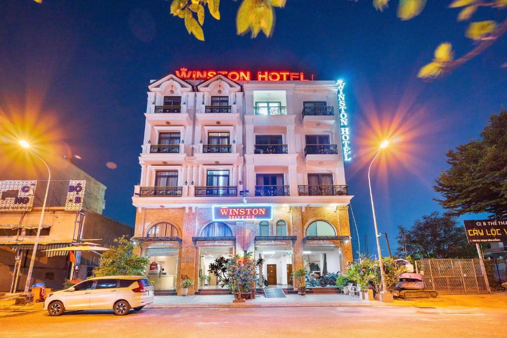 a white van parked in front of a building at Winston Hotel Riverside in Ho Chi Minh City