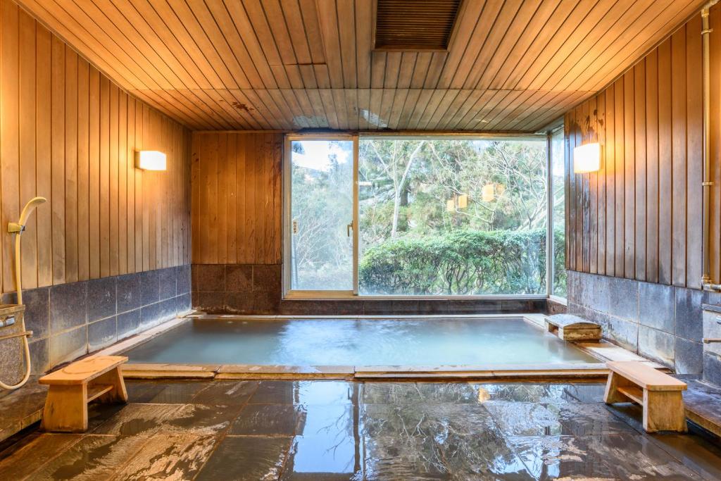 bañera en una habitación con ventana en Hakone Gora Onsen Yumenoyu, en Hakone